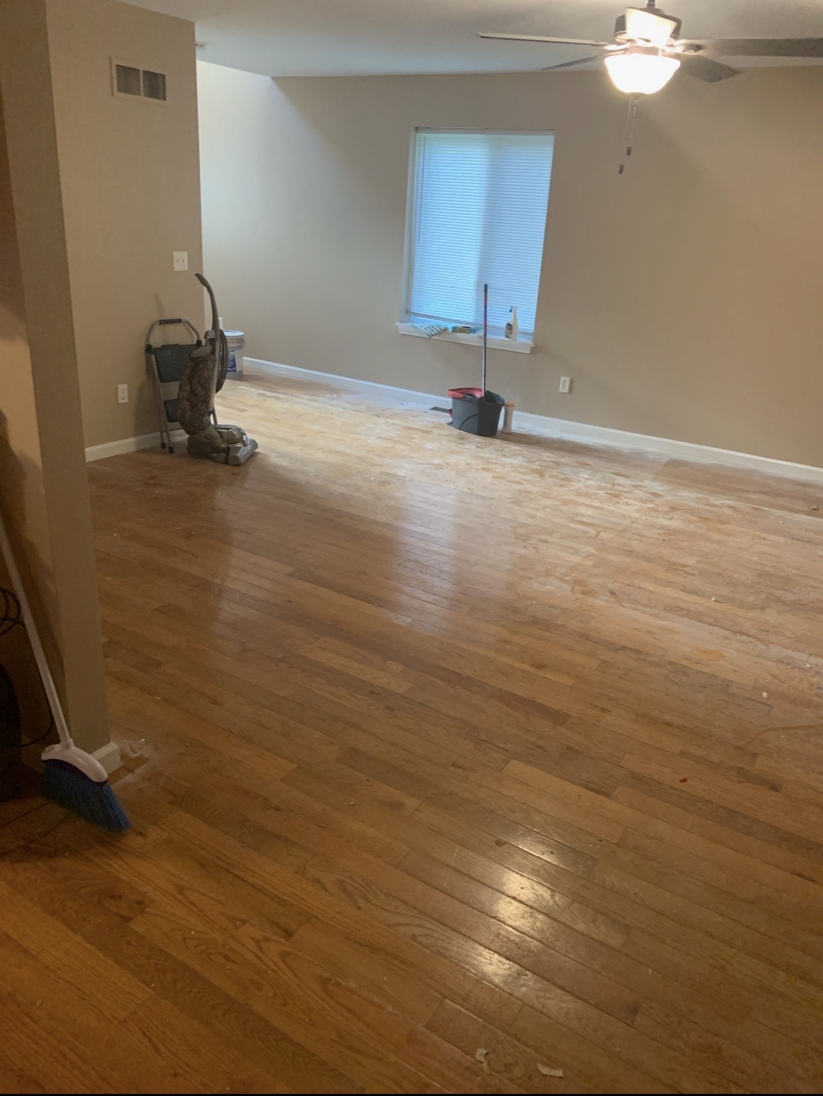 Living room hardwood before QCC post-construction cleaning — dust and construction residue